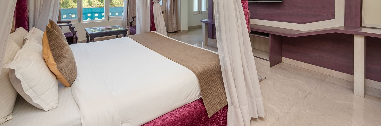 Luxurious bedroom at DLS Tehri Club Resort with a four-poster bed and elegant decor.